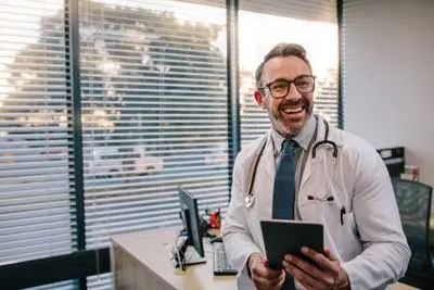 Doctor sitting on his desk smiling in his office | Florida Pest Control serving Gainesville, FL